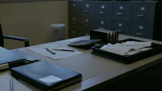 LA County abuse settlement payment schedule: a finance office desk with sealed envelopes